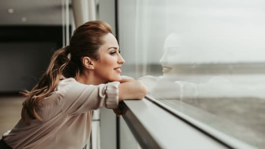 woman staring outside of office window looking proud