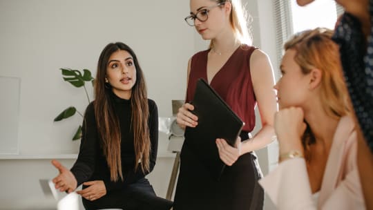 Woman speaking with team members