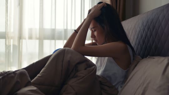 Anxious woman in bed