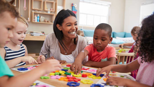 young teacher crouching by group of students