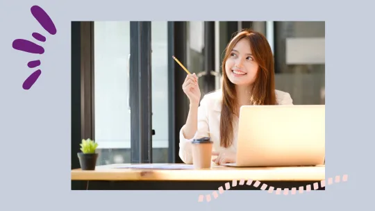 a woman sitting at a laptop looking happy. 