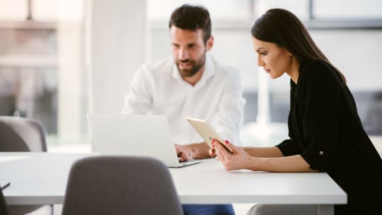 Woman sitting with man at work