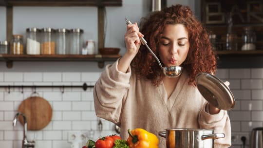 woman cooking soup after work