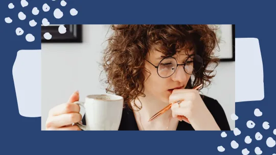 woman thinking while holding a coffee cup and pen