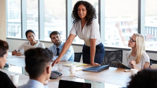 A woman stands up to lead a meeting