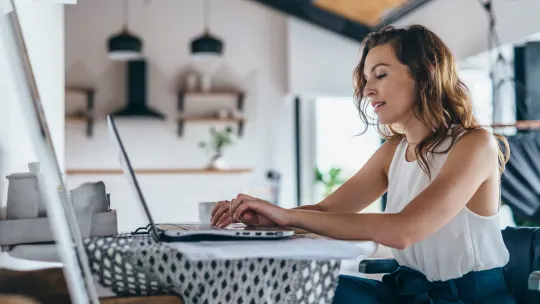 woman sitting at table typing