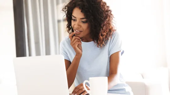 woman looking curiously at laptop