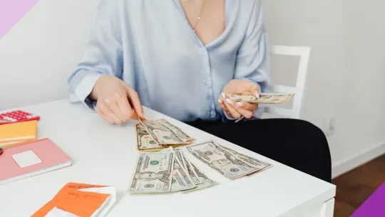 A person calculating money, illustrating the 50/30/20 rule