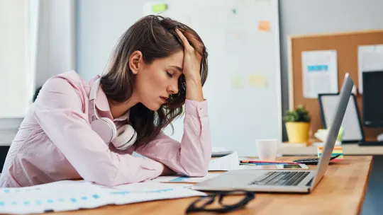 Stressed woman sits at desk