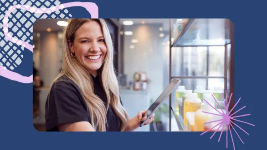 a woman smiling while holding a tablet