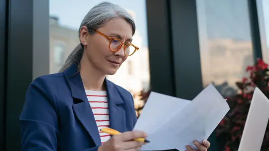 Woman looking at papers thinking