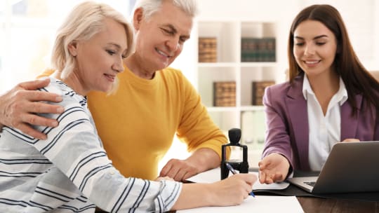 A notary about to stamp an older couple's documents