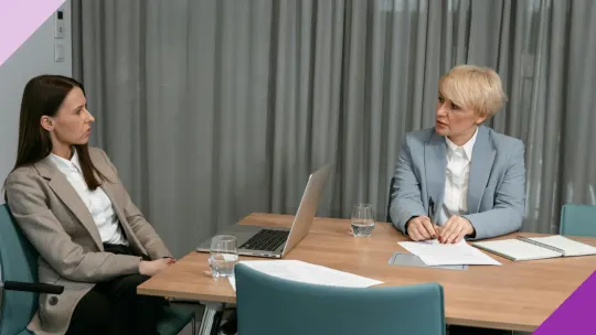 Two women having a serious conversation at an office to illustrate the importance of learning when you should report your boss.