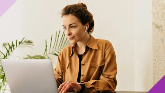 A woman at her office concentrated while typing on a laptop to illustrate the importance of learning how to research a company for an interview