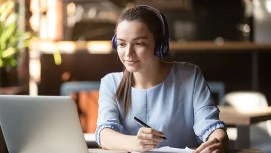 translator listening with headset and taking notes