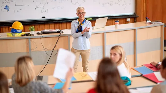 professor lecturing in front of students in a classroom