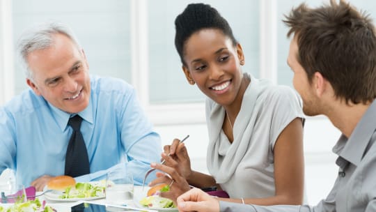 colleagues eating and talking at a business lunch