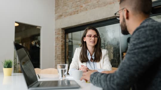 A woman looks at an interviewer nervously