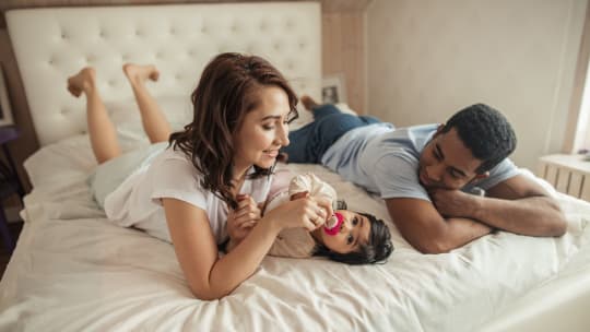 Parents and baby in bed