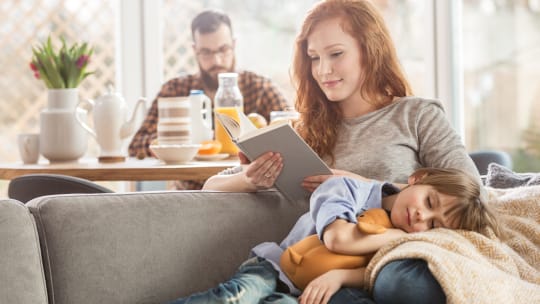 mother reading with son asleep