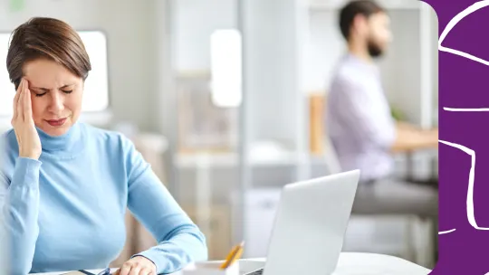 a woman with a migraine at work