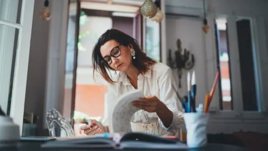 Woman flipping through papers in a creative field