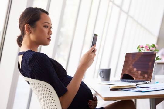 Pregnant woman looking at phone