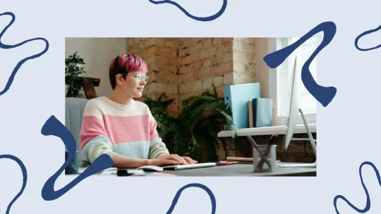 Woman sitting on couch, smiling at her computer