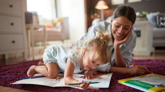 babysitter watching a toddler color