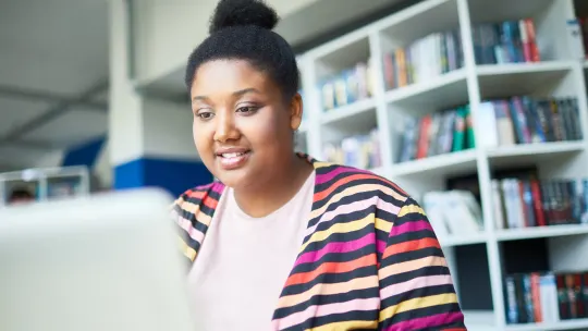 college student in the library on her laptop