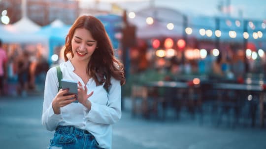 woman traveling abroad checking a language dictionary