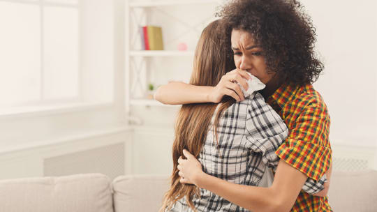 Woman comforting woman