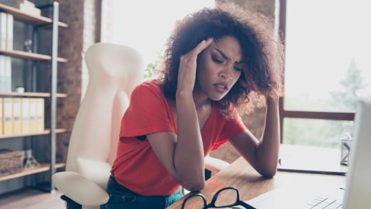 woman with migraine at work