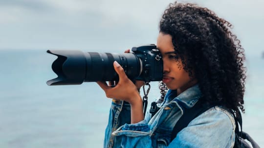 woman taking photos by the water