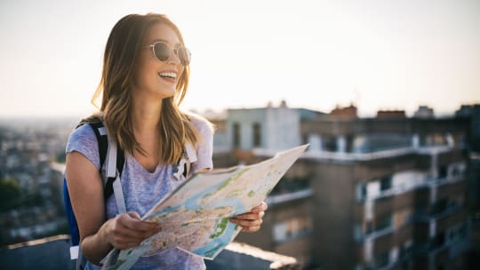 young woman holding a map while traveling