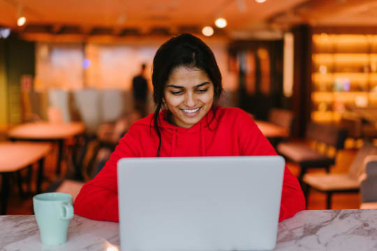 A woman sits in front of a laptop