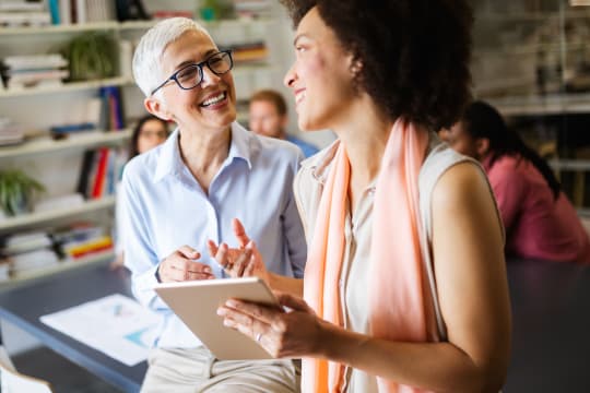 Older and Younger Woman Talking at Work