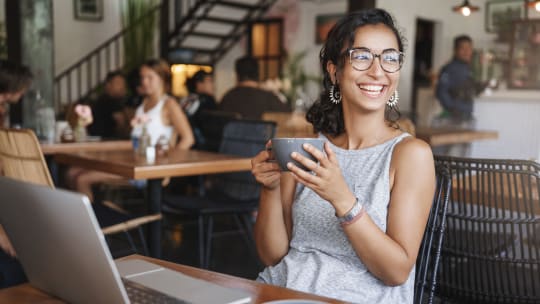 Woman smiling and drinking coffee