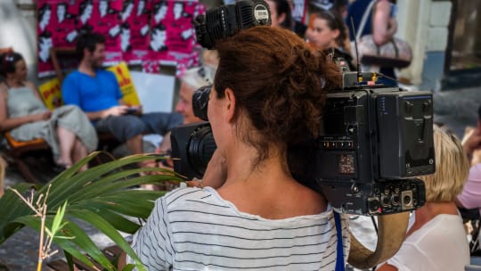 women holding a TV camera