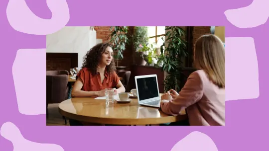 women sitting across from one another in an interview