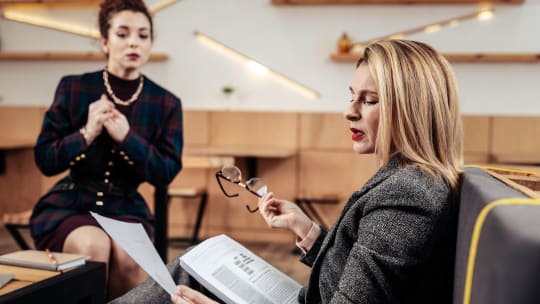 woman looking over a direct reports paperwork with disgust