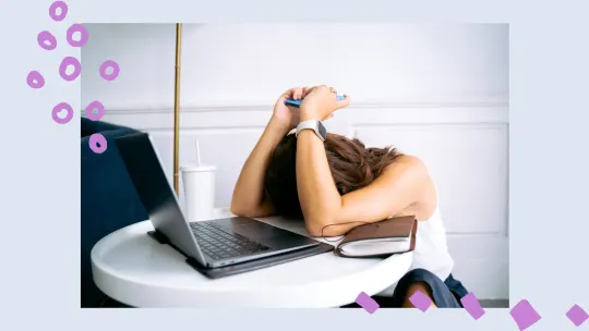 a woman with her head down on a desk