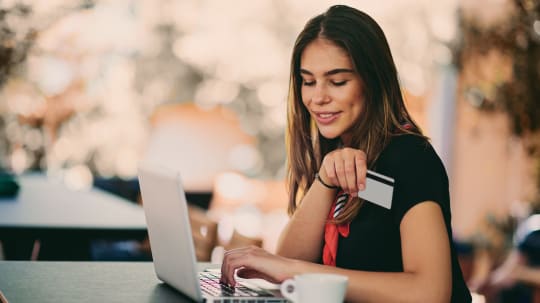 woman putting coin in piggy bank
