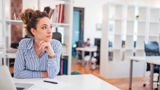 concentrated woman looking out in her office