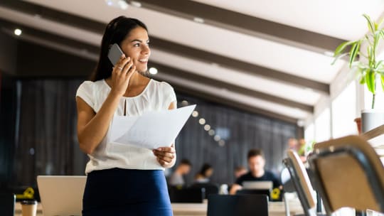 woman on the phone looking at a resume