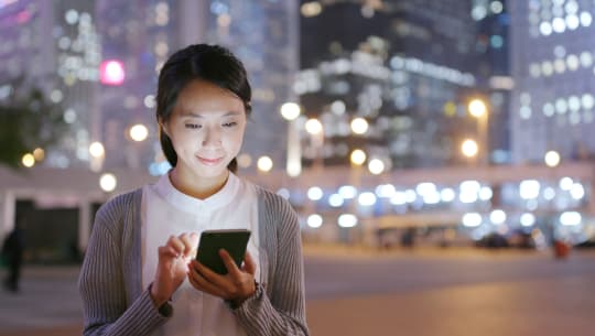 Woman looking at phone at night