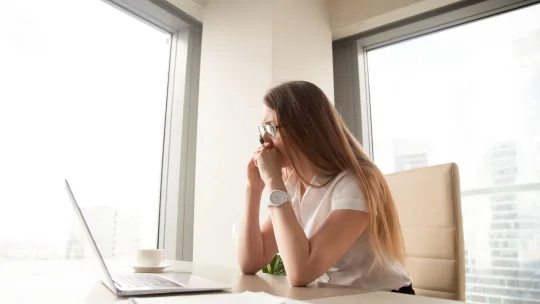 woman sitting in front of her laptop looking stressed