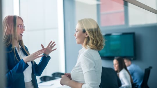 two women at work having a conversation