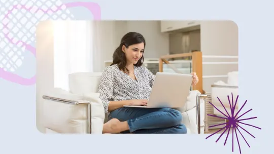 a woman sitting on a sofa typing on her laptop.