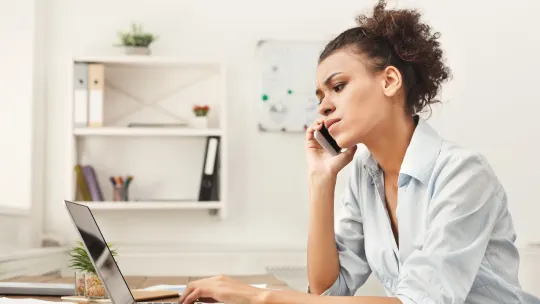 Concentrated business woman talking on phone